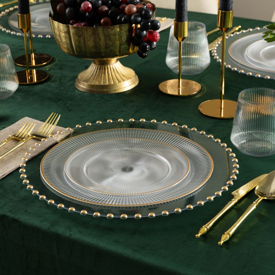 Linear Collection clear plates with gold rim on a green velvet table