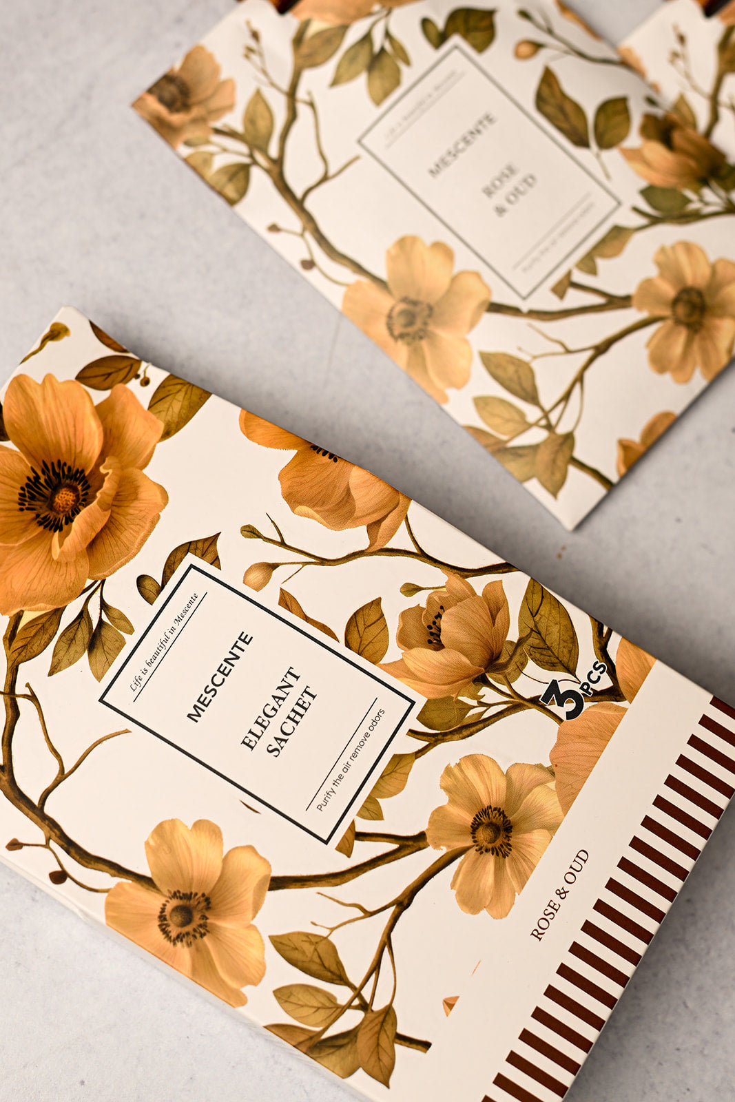Mescente Rose and Oud scented sachets close up with amber ribbons