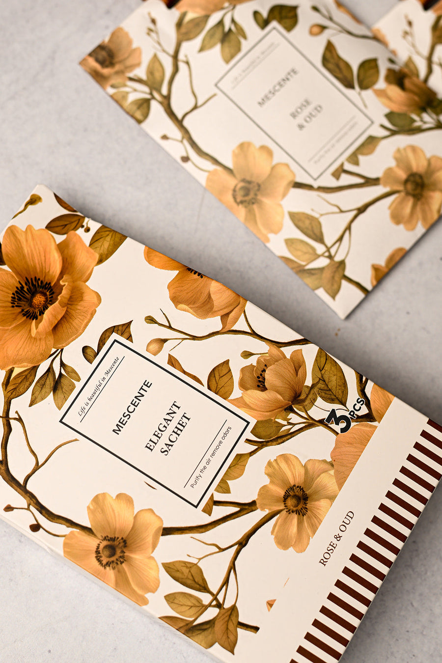 Mescente Rose and Oud scented sachets close up with amber ribbons