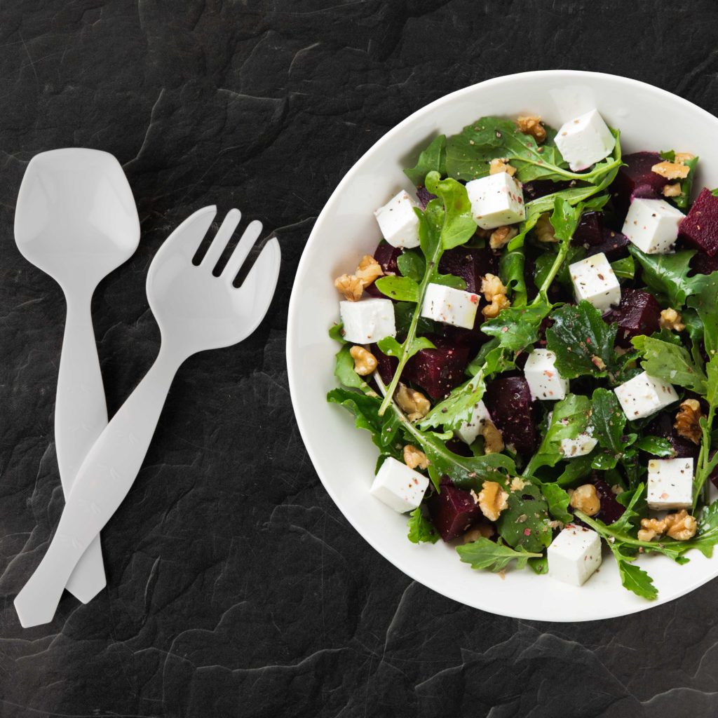 White serving spoon shown with a serving fork beside a salad bowl, spoon sold on its own - The Closeout Connection #Color_White