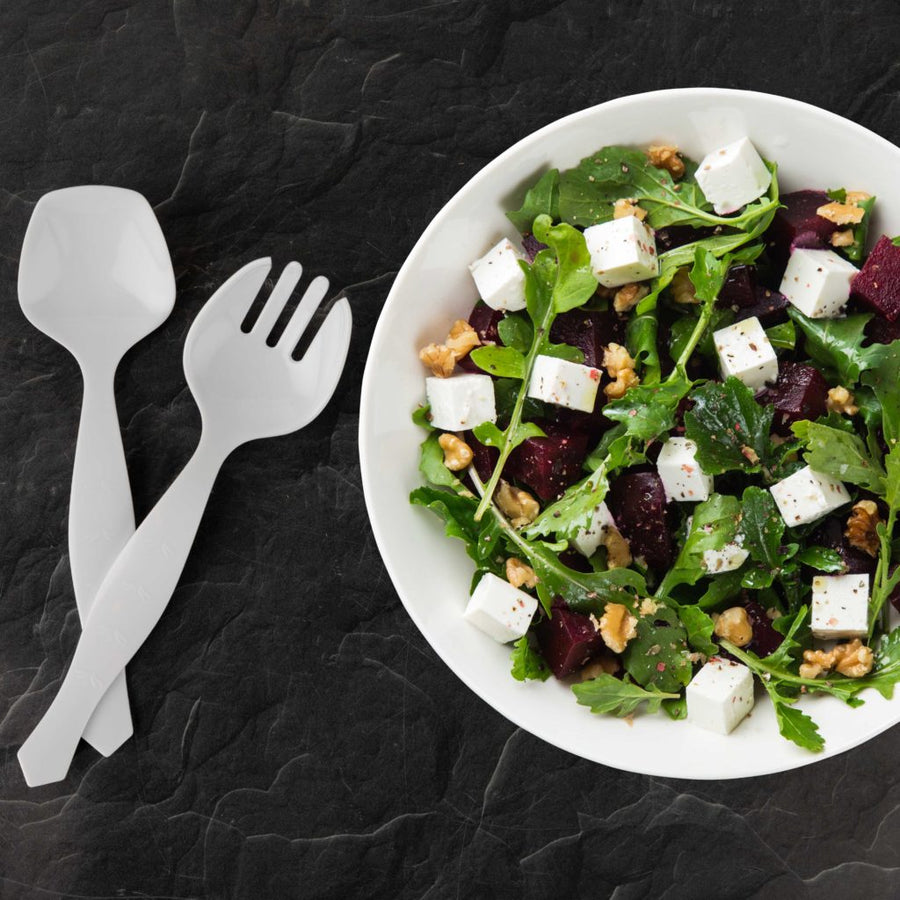 White serving spoon shown with a serving fork beside a salad bowl, spoon sold on its own - The Closeout Connection 